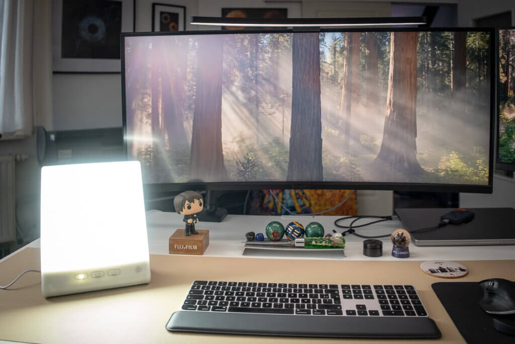 Lampe de luminothérapie Beurer TL 45 allumée sur un bureau, utilisée pendant une séance matinale devant un écran d’ordinateur.